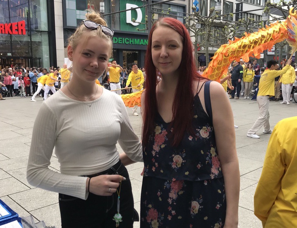 图10:科琳娜(Corinna)和女儿艾芙琳(Eveline)观看法轮功学员庆祝大法日的活动,赞同真、善、忍。